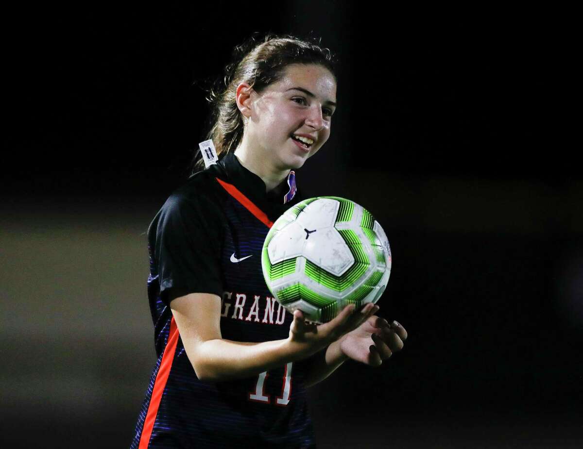 Grand Oaks midfielder Lauren Moylan (11) laughs before throwing the ball in bounds during the first period of a non-district high school soccer match at Grand Oaks High School, Friday, Jan. 22, 2021, in Spring.