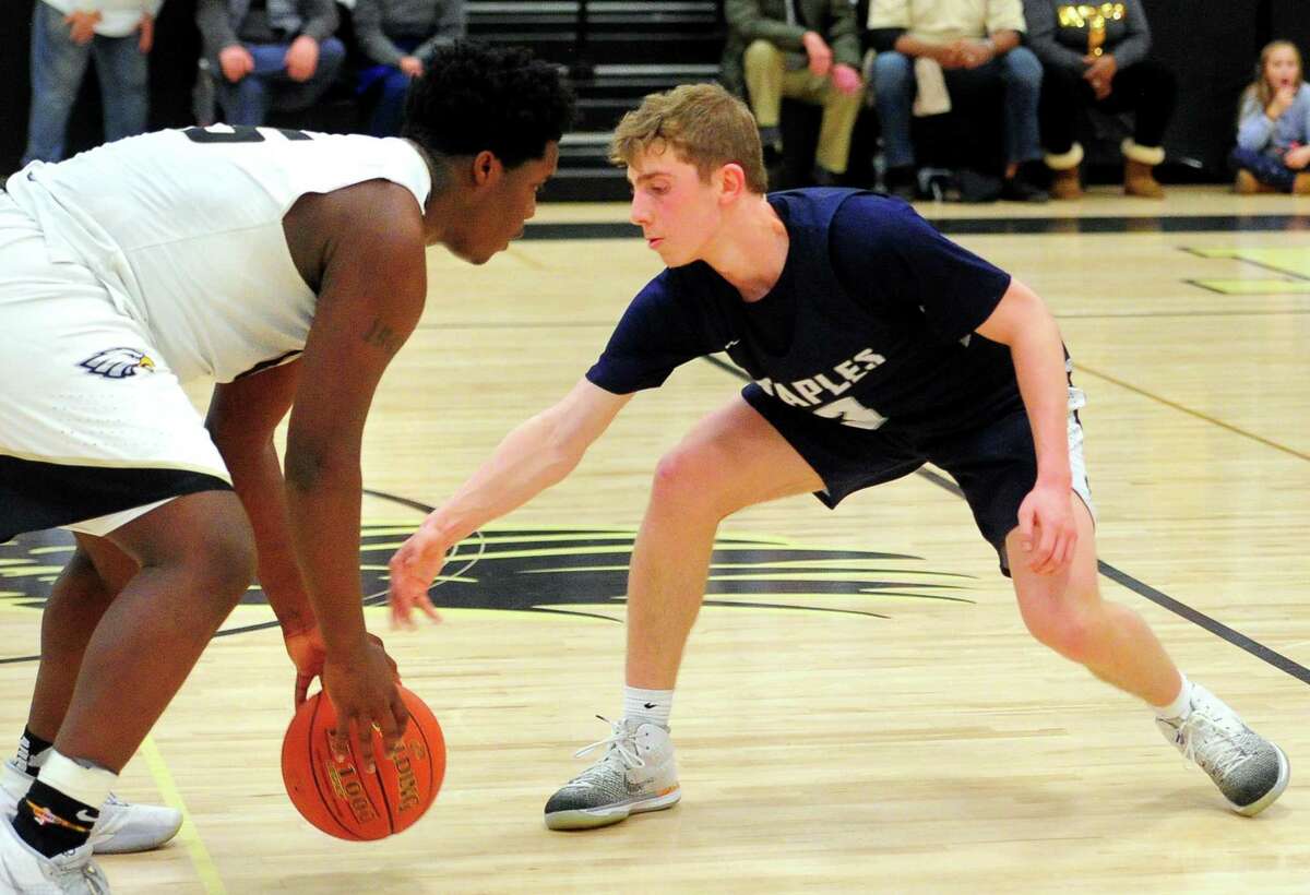 Staples' Derek Sale (3) reaches for the ball as Trumbull's Quentar Taylor (45) dribbles it during boys basketball action in Trumbull, Conn., on Friday Jan. 17, 2020.