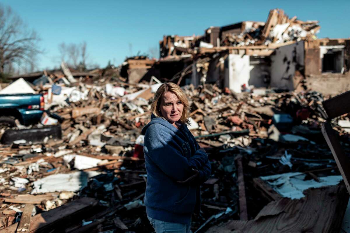 Dawn Humphrey stands amid the rubble outside her home at the Dawson Village Apartments complex in Dawson Springs, Ky., on Monday, Dec. 13, 2021. She and her son rode out the storm in their bathroom. (William Widmer/The New York Times)