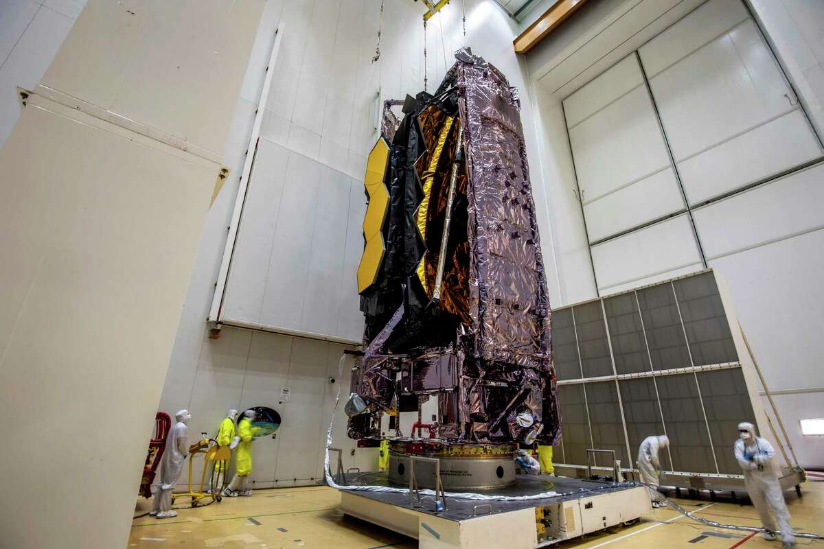 In this Saturday, Dec. 11, 2021 photo released by the European Space Agency, NASA’s James Webb Space Telescope is secured on top of the Ariane 5 rocket that will launch it to space from French Guiana.