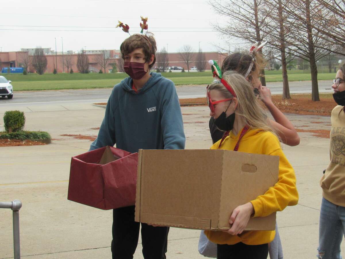 Max Horton and Kaitlyn Hatfield wore festive gear while delivering donations from Lincoln Middle School's food and toy drive on Wednesday morning. 