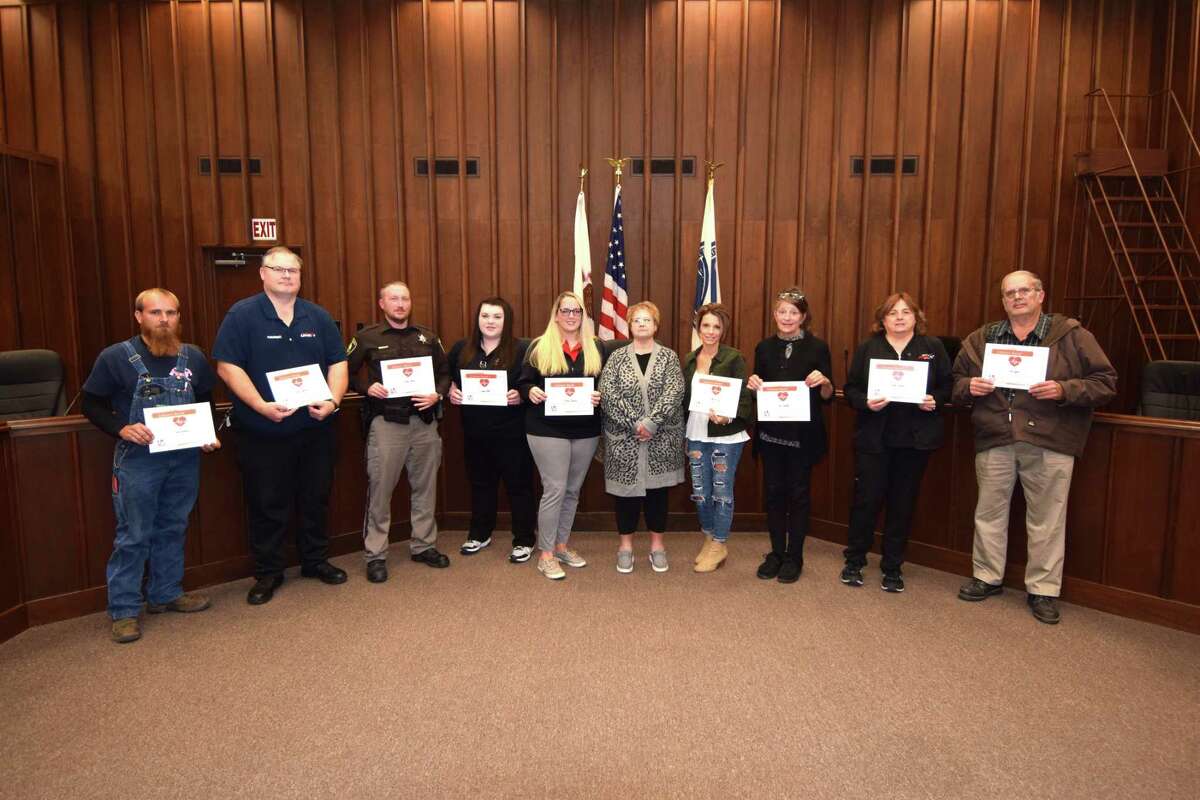First responders to a July 3 emergency pose with their recognition certificates recently at the Jacksonville Municipal Building. From the left, Sam Carpenter, Jason Shumaker, Jamie Bettis, Lynne Bell, JaNece Sweeten, heart attack survivor Holly Shanks, Aleece Ford, Gina Hamilton, Betty Stewart, and Ron Lyons.