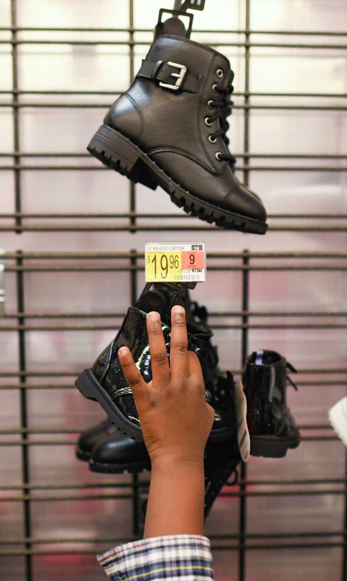 A child chooses footwear Thursday at a WalMart on West Military Drive, paid for by a holiday fundraising project by John Jay High School students that started in 1967.