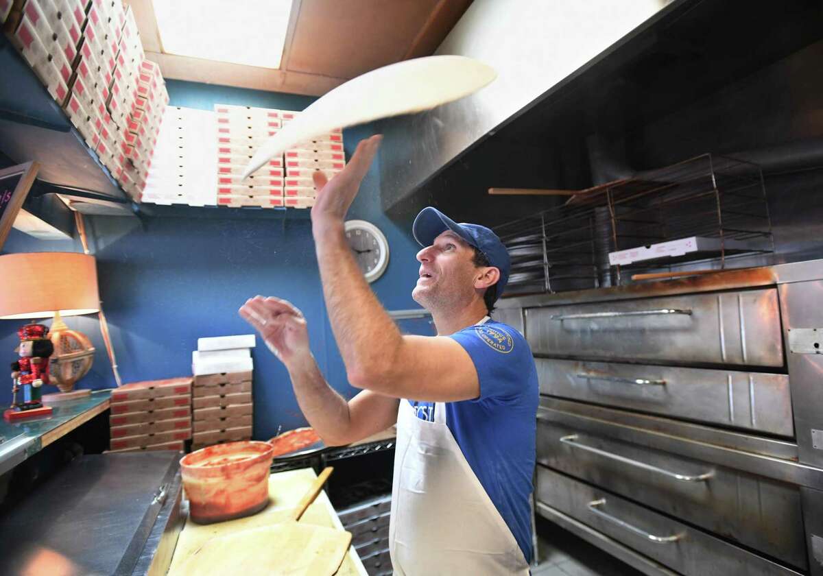 Andrew Pane makes a pizza at his Pizza Post of Fairfield restaurant at 200 Tunxis Hill Road in Fairfield, Conn. on Friday, December 10, 2021.