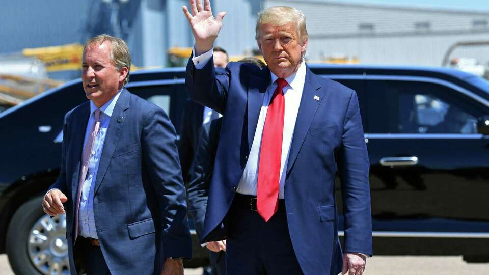 In this file photo, US President Donald Trump waves upon arrival, alongside Attorney General of Texas Ken Paxton (L) in Dallas, Texas, on June 11, 2020. (Nicholas Kamm/AFP via Getty Images/TNS)