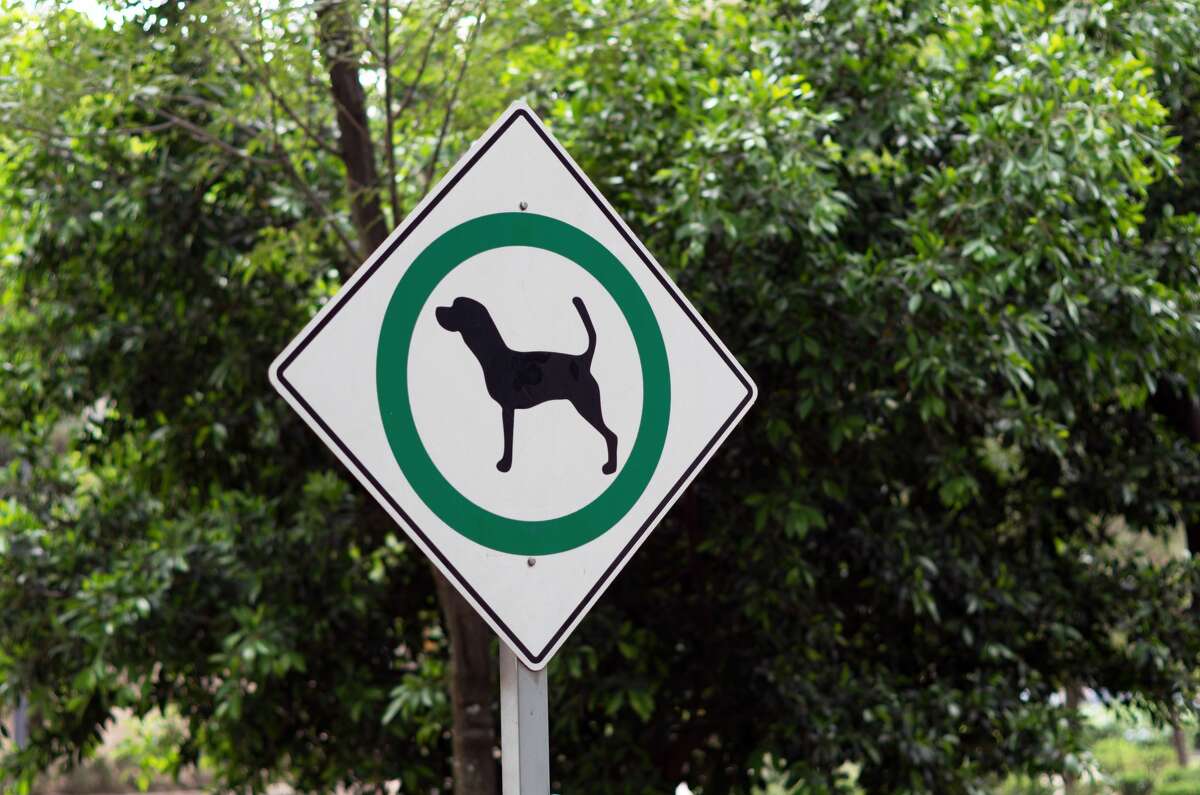 A park sign signaling dogs are permitted to be off-leash.