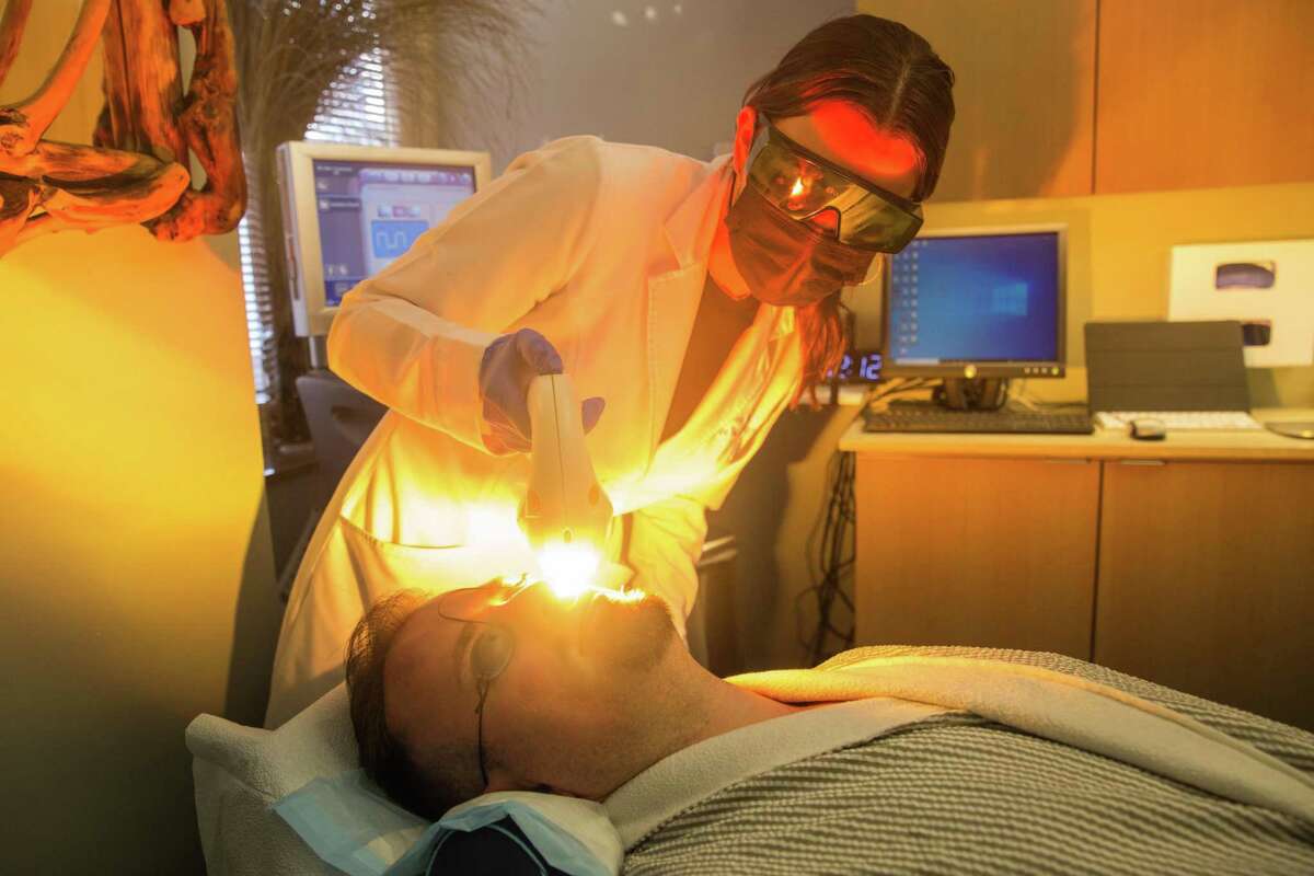 Registered nurse Kristine Meister performs photo facial treatment on Michael Ibarra at Epi Center MedSpa in San Francisco.