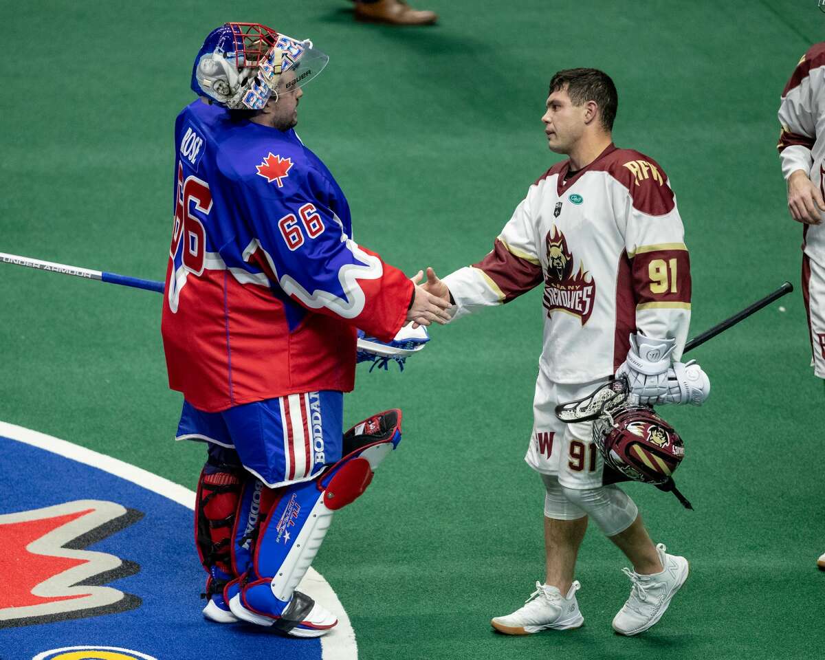 Albany Firewolves defenseman/faceoff man Joe Nardella, right, shakes hands with Toronto goalie Nick Rose after their game on Dec. 4, 2021. (Christian Bender/NLL)