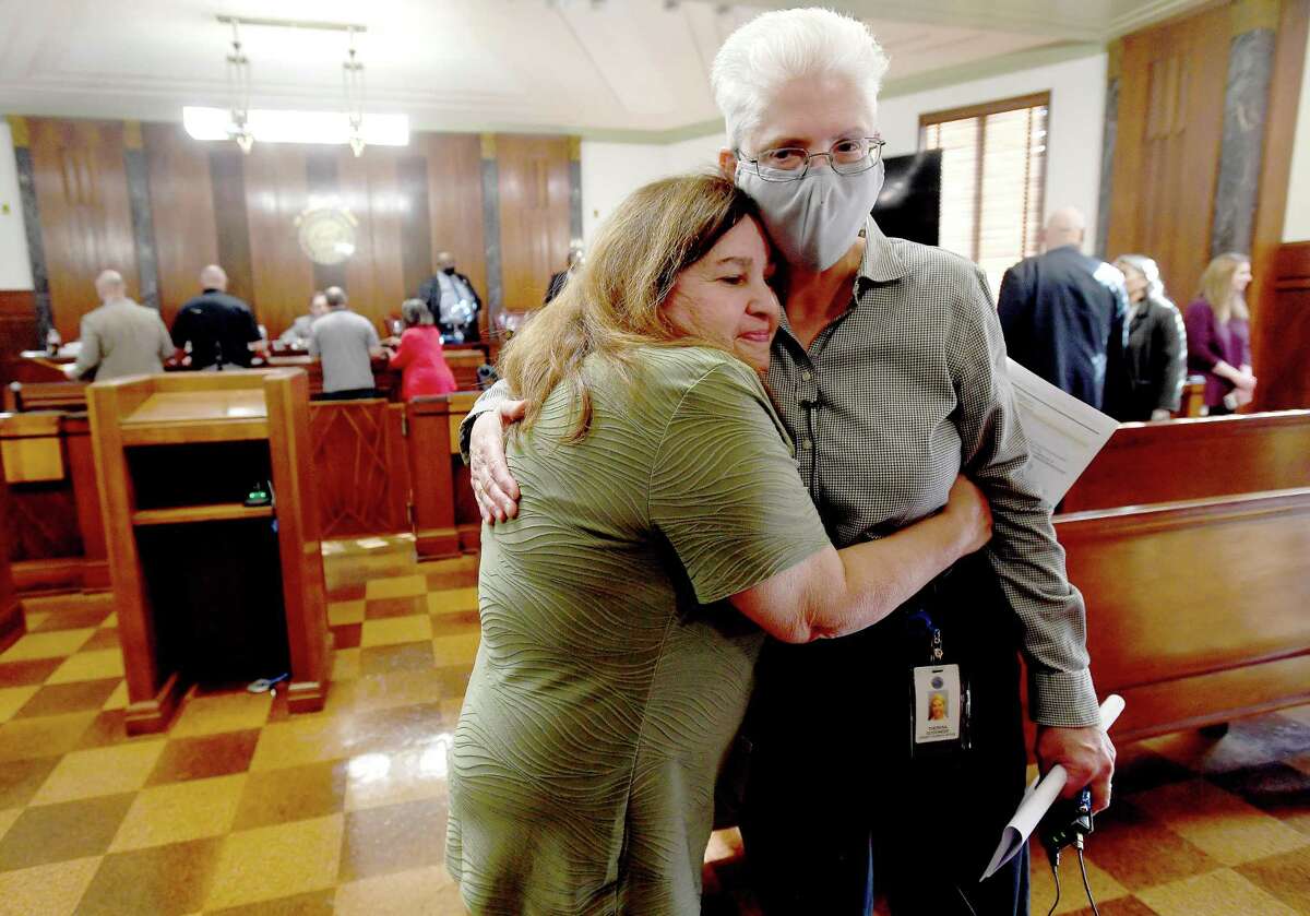 Jefferson County Clerk Theresa Goodness gets a hug from Allison Getz after she received a flag and certificate in honor of her 34 years of service to the county during the Commissioners Court meeting Thursday. Goodness will be retiring at the end of the month. Photo made Thursday, December 16, 2021 Kim Brent/The Enterprise