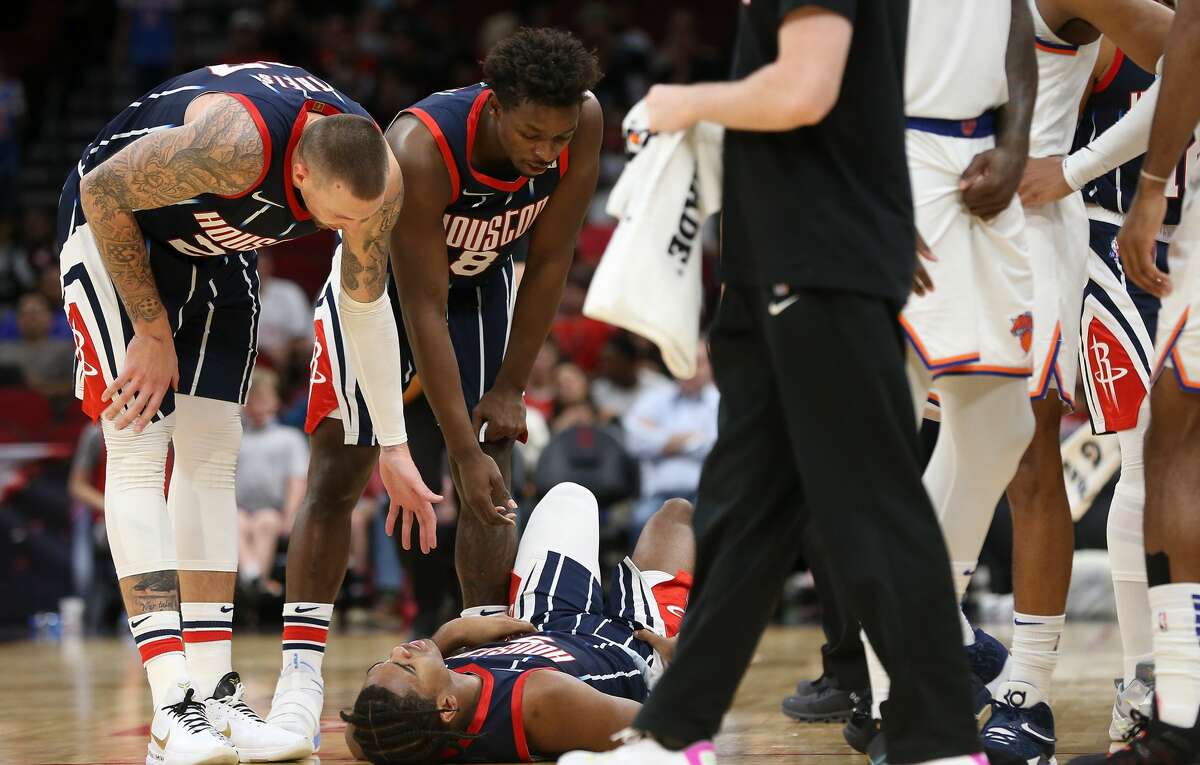 Houston Rockets gather around Houston Rockets guard Josh Christopher (9) who was down after a mid-court collision at the Toyota Center in Houston on Thursday, Dec. 16, 2021. New York Knicks won the game 116-103.