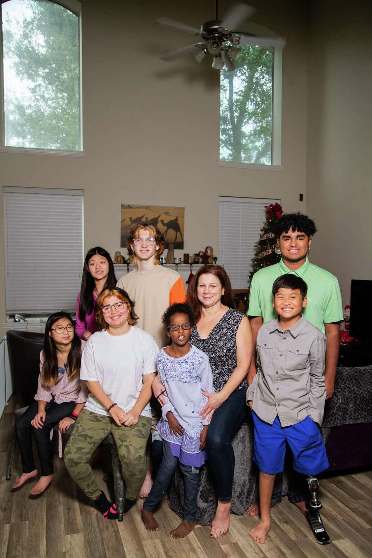 Kaitlyn, 14, Lucy, 18, Krasi, 18, Evan, 14, Sadee, 10, Tray, 11, and Sergio, 15, with their mother Debbie Sarich, center, at their home in Spring. 