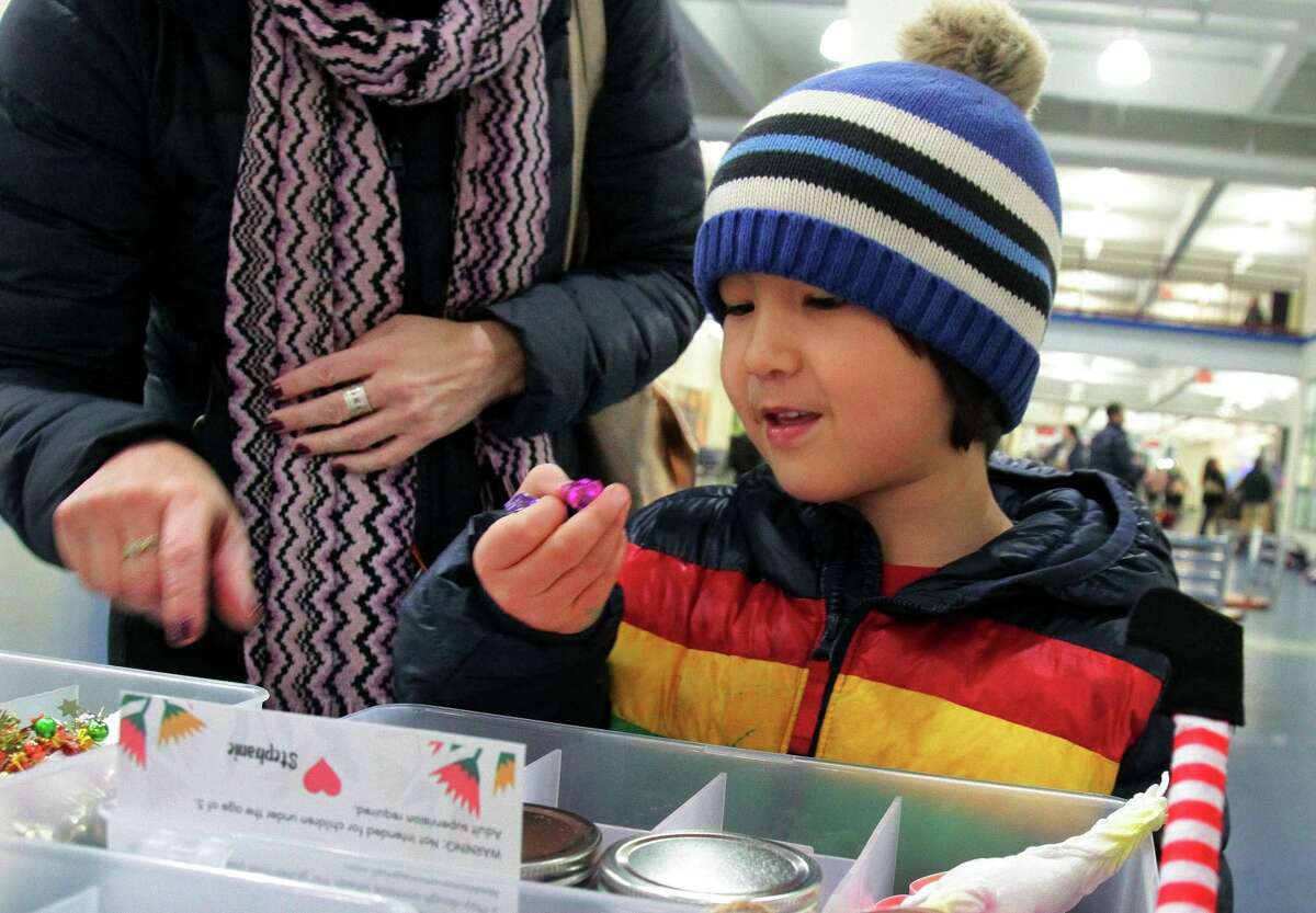 Bowen Skwara, 5, of Stamford, checks out items for sale by vendor Mrs. Mamavation during Chelsea Piers' annual Holiday Sip + Shop in Stamford, Conn., on Wednesday December 15, 2021. Forty plus vendors lined the halls and offered crafts, books, ornaments, clothing boutiques, candles, jewelry and were just a few of the offerings to visitors.