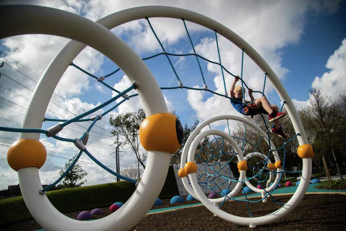Trace Newcomer, 6, plays on a spider web playground facility in the Woodchase Park, Wednesday, Dec. 15, 2021, in Houston.
