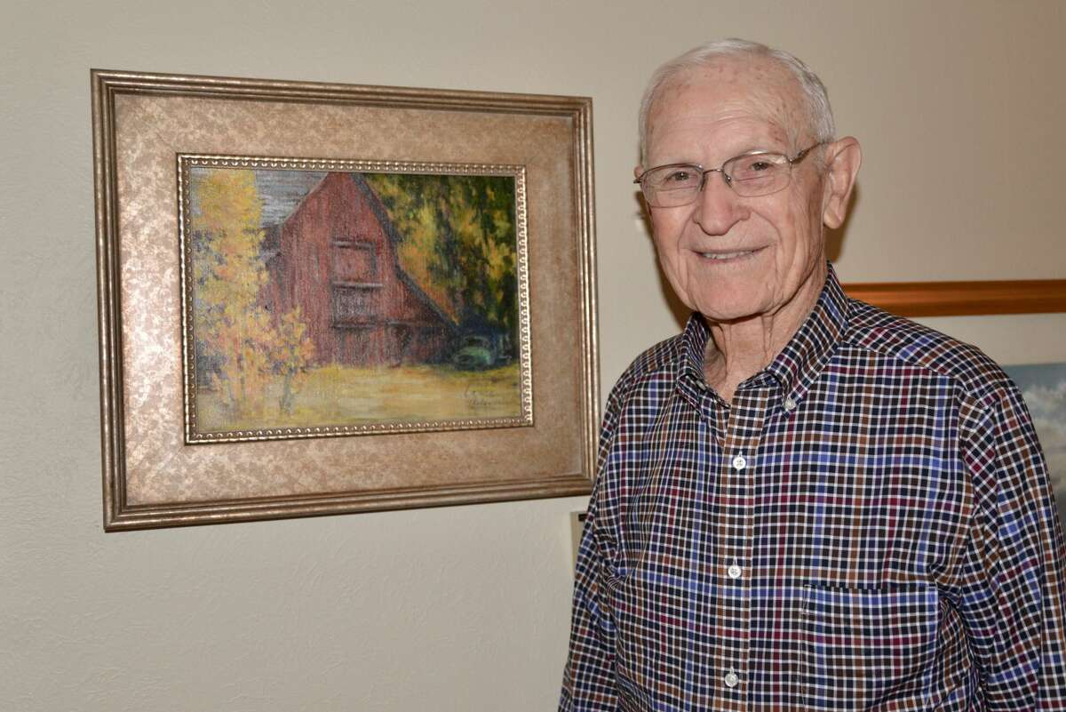 Ken Peeler, fall 2018, standing by one of his LaVoe’s (his wife) paintings.