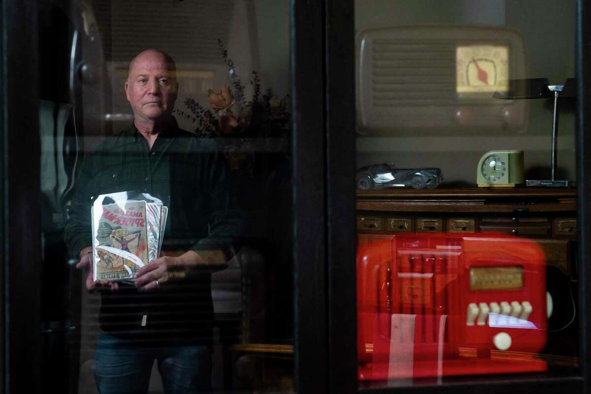 Comic book collector Mark Michaelson stands with some of his comic books near the vintage radios he also collects in his home, Monday, Dec. 13, 2021, in Houston. Michaelson recently listed his most valuable comic book, a first-edition Superman, for auction. The rare comic is up to over $2 million with days left.
