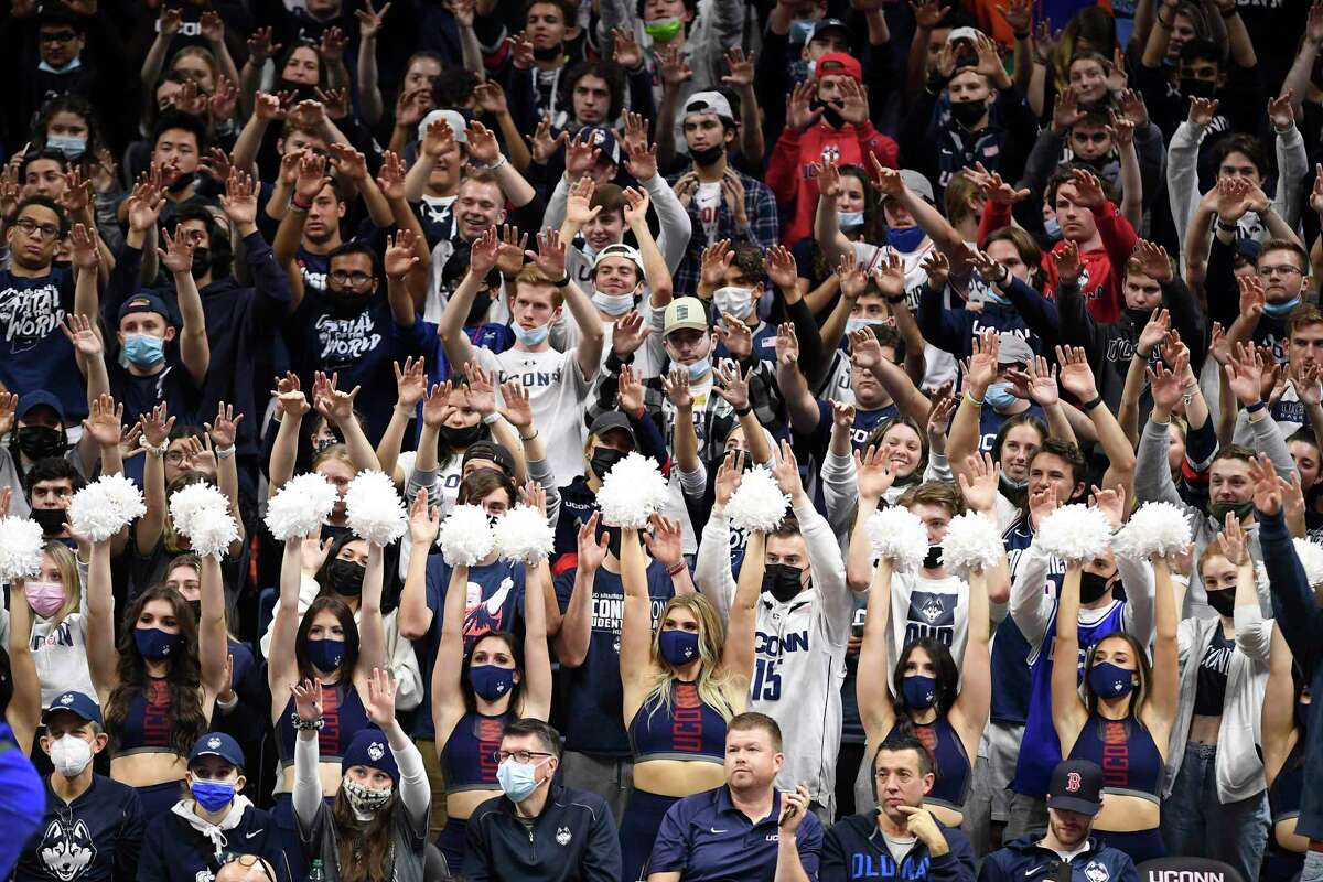 Above, UConn fans were back in full force at Gampel Pavilion for a November game in Storrss. Below, an injured Paige Bueckers holds her crutches while watching a game from the sidelines. Right top, new UConn football coach Jim Mora talks with reporters. Right second from top, Ridgefield’s Kieran Smith of Team United States reacts during the Tokyo Olympic Games. Right third from top, Harris English looks at the trophy after winning the Travelers Championship. Right second from bottom, Bristol Central’s Donovan Clingan chose to stay in Connecticut and will play basketball at UConn. Right bottom. Bristol Central football standout Victor Rosas will also be staying in the state and will be playing football for the Huskies.