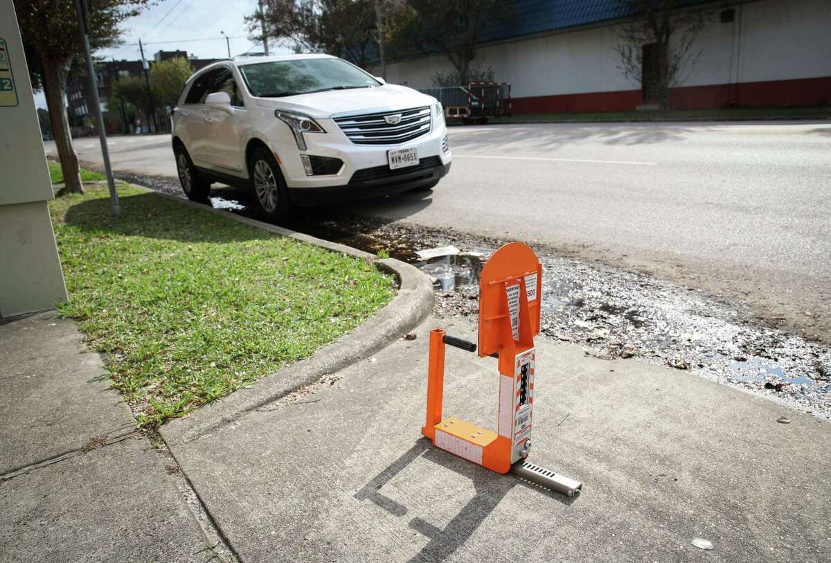 A boot sits on a sidewalk before a demonstration of the new system Thursday, Dec. 9, 2021, near the intersection of St. Emanuel Street and McKinney Street in Houston. The new boot can be paid for and unlocked remotely.