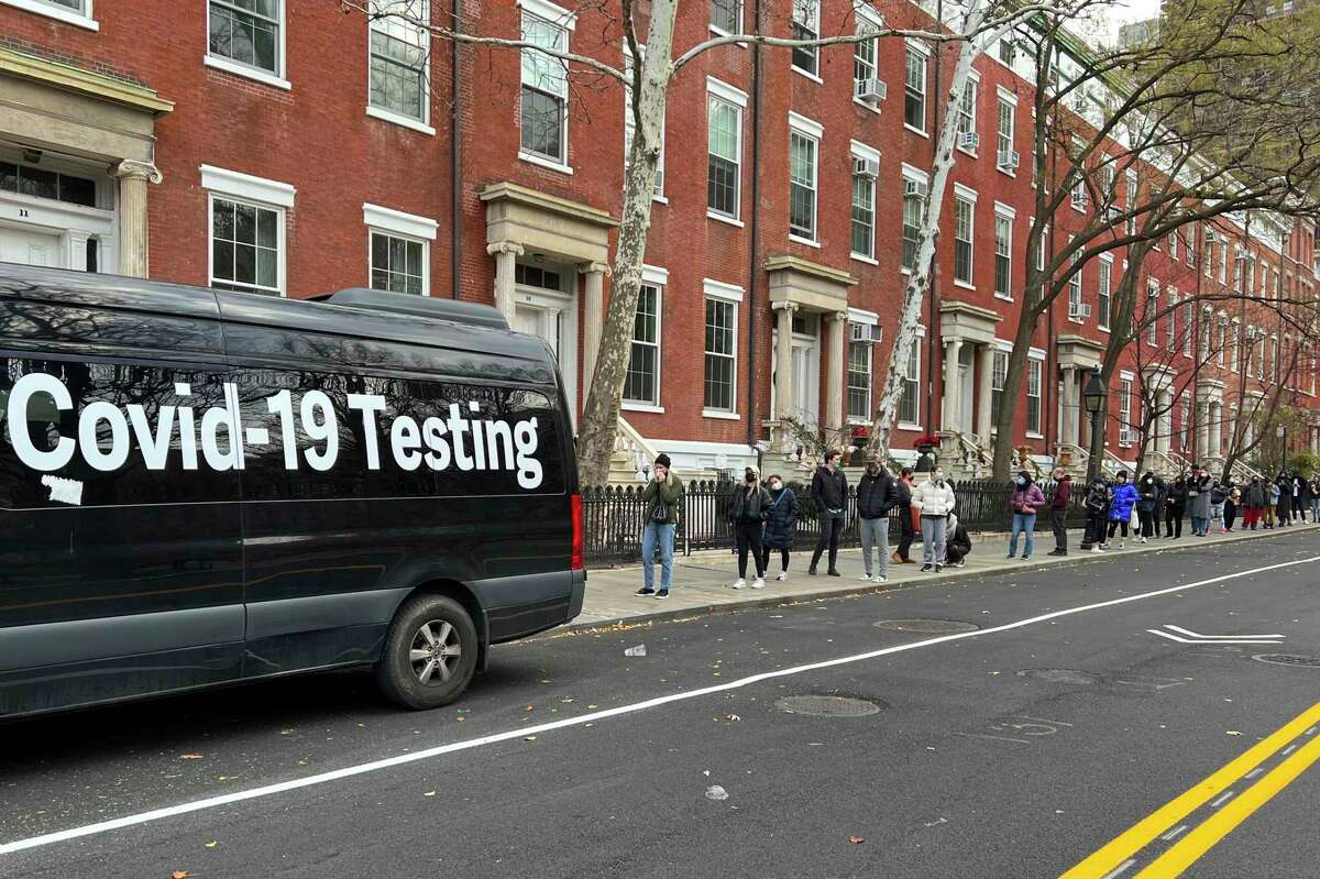 A line stretches down the block Thursday as people wait in line to be tested for the coronavirus in New York. The omicron variant has a strong foothold in New York City and is expected to sweep across the U.S. shortly.