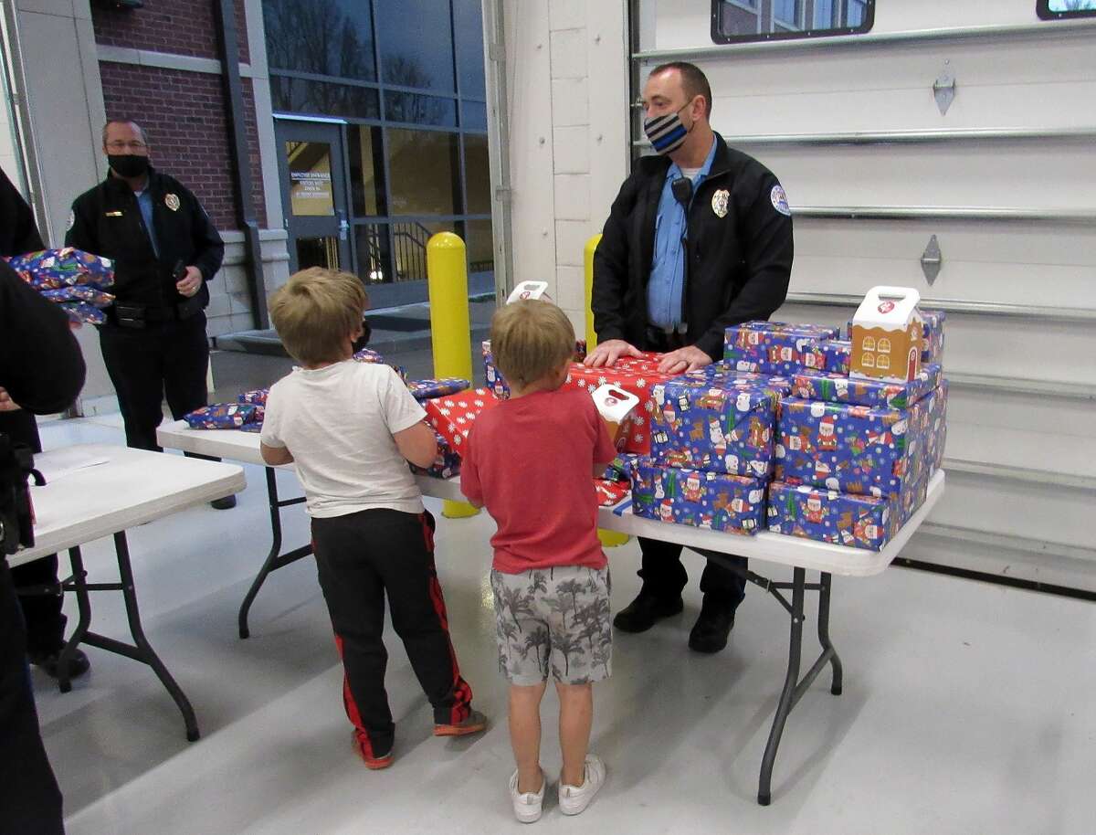Two children receive their gifts from Sergeant Matt Breihan during during Friday's "Christmas with a Cop" event at the Edwardsville Police Station.