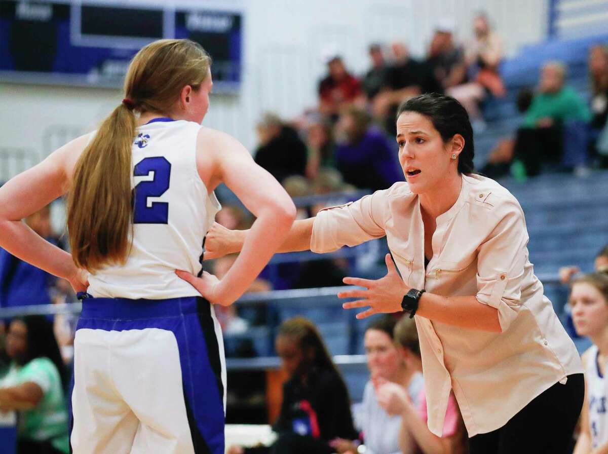 New Caney head coach Dani Froggatt talks with point guard Abby Dittman (22) during the first quarter of a high school basketball game at New Caney High School, Friday, Dec. 17, 2021, in New Caney.