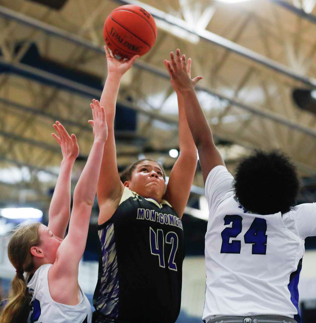 Montgomery forward Janessa Tennison (42) shoots a contested shot during the first quarter of a high school basketball game at New Caney High School, Friday, Dec. 17, 2021, in New Caney.
