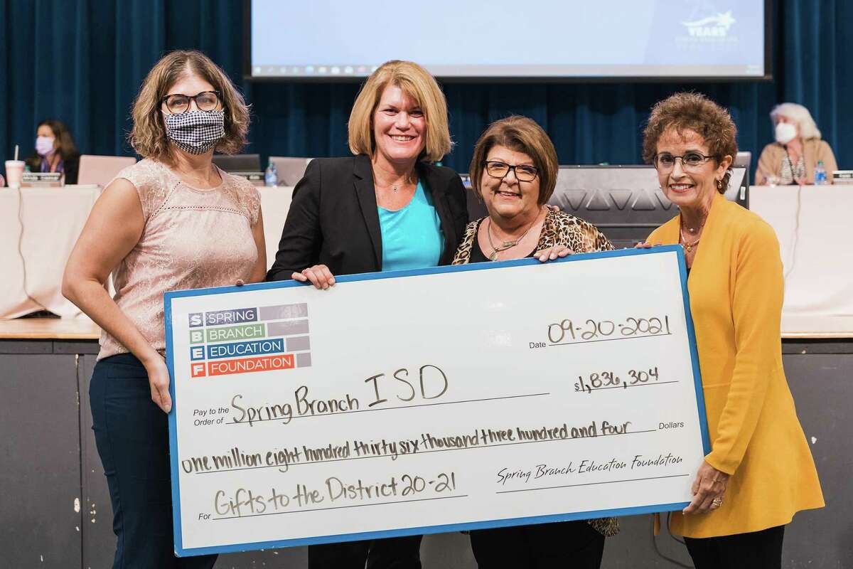 Spring Branch Education board chair Lisa Schwartz (far right) and executive director Cece Thompson (second from right) present a check for $1,836,304 from the foundation to Spring Branch ISD superintendent Jennifer Blaine (second from left) and board president Chris Gonzalez during the Sept. 21 board meeting.