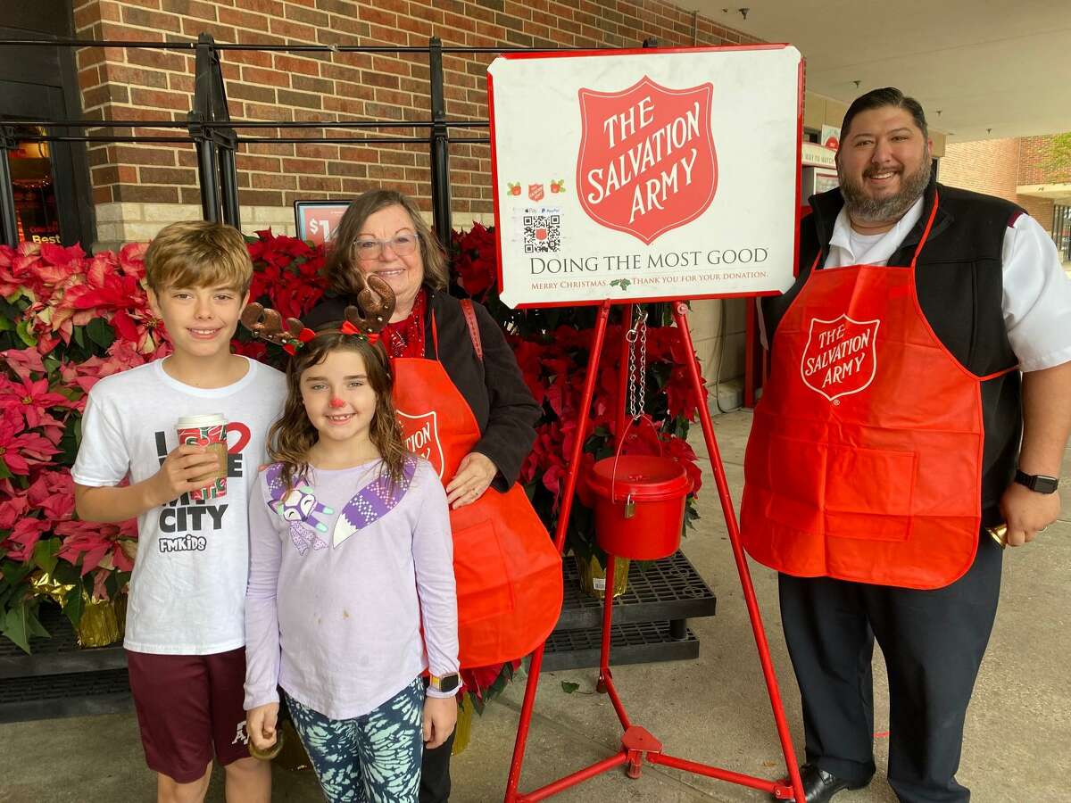From left, The Kelly family and Lt. James Guzman from the Salvation Army ring bells for the Salvation Army on behalf of the Rotary Club of Conroe.