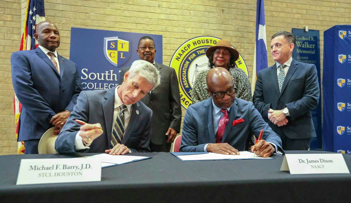 South Texas College of Law Houston Dean Michael Barry, left, and Dr. James Dixon, Board President of NAACP Houston Branch sign a memorandum of understanding at South Texas College of Law Houston, Friday, Dec. 17, 2021 in Houston . The memorandum of understanding is to declare their attempts to fight for clemency for soldiers of the 24th Infantry Regiment. They were convicted by General CourtMartial in 1917 for their Involvement in an alleged mutiny at Camp Logan in Houston.
