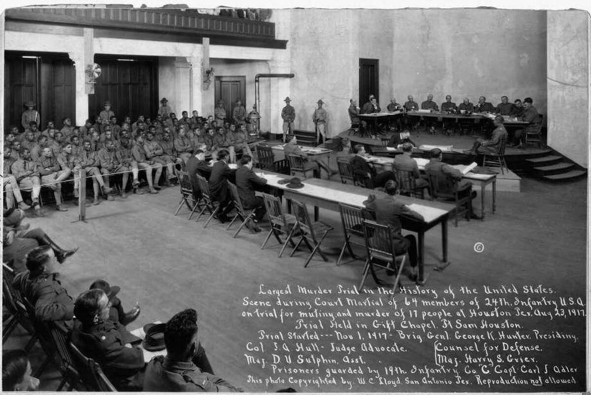 An archival photo from the U.S. War Department. The caption reads, "Largest Murder Trial in the History of the United States. Scene during Court Martial of 64 members of the 24th Infantry United States of America on trial for mutiny and murder of 17 people at Houston, Texas August 23, 1917. Trial held in Gift Chapel Fort Sam Houston. The Houston Riot of 1917, or Camp Logan Riot, was a mutiny by 156 African American soldiers of the Third Battalion of the all-black Twenty-fourth United States Infantry. It occupied most of one night, and resulted in the deaths of four soldiers and sixteen civilians. The rioting soldiers were tried at three courts-martial. A total of nineteen would be executed, and forty-one were given life sentences."