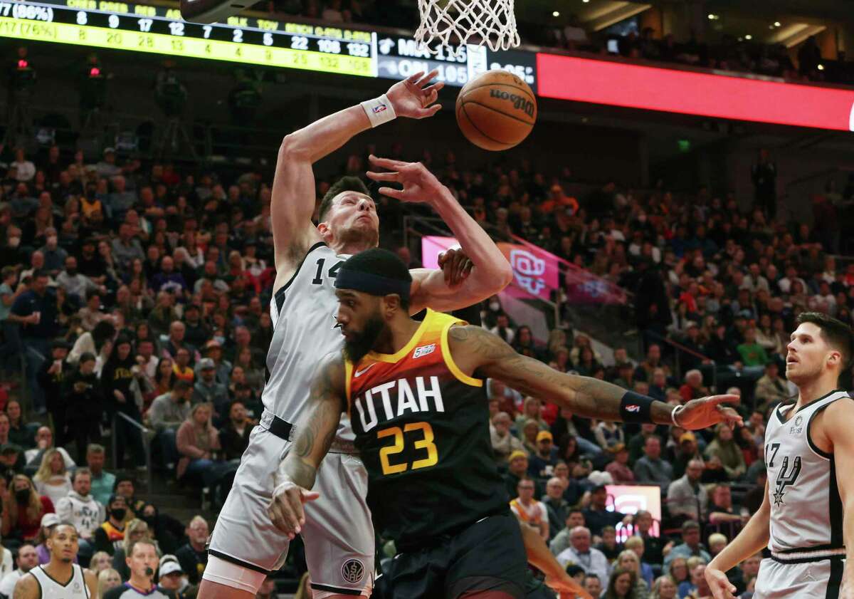 San Antonio Spurs forward Drew Eubanks (14) attempt a layup as Utah Jazz forward Royce O'Neale (23) defends during the first half of an NBA basketball game on Friday, Dec. 17 2021, in Salt Lake City. (AP Photo/Kim Raff)