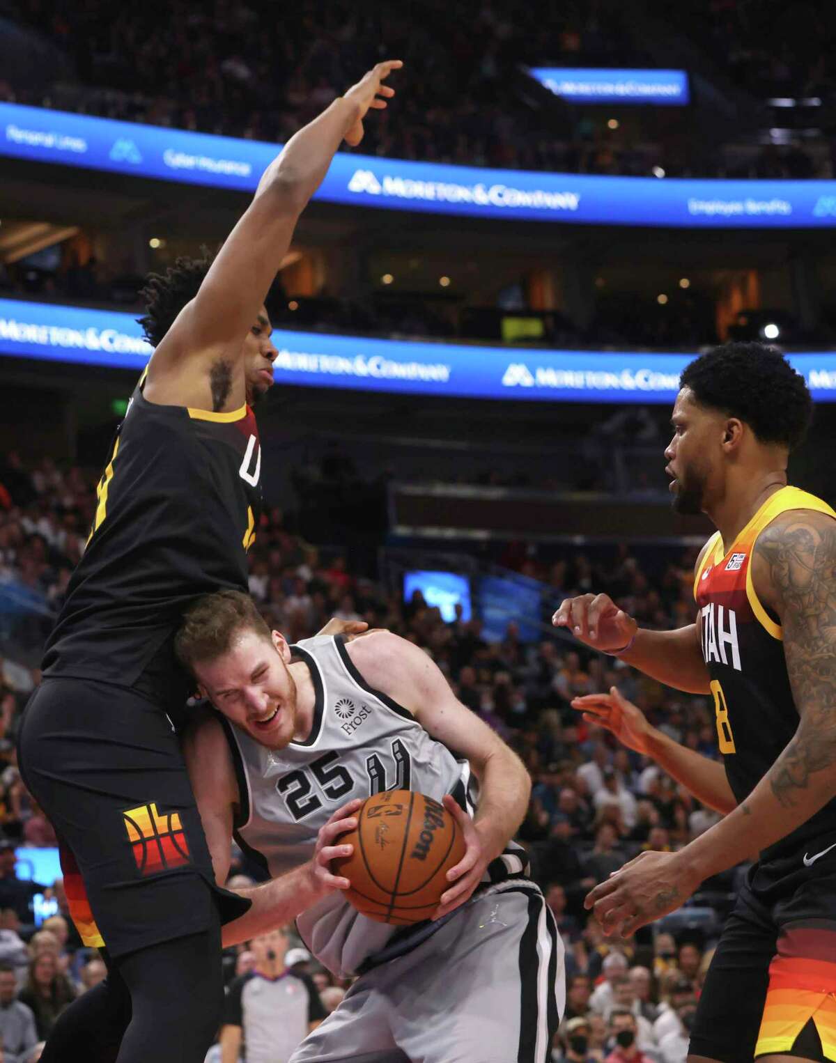 San Antonio Spurs center Jakob Poeltl (25) looks for an opening as Utah Jazz center Hassan Whiteside, left, and Rudy Gay (8) defend during the first half of an NBA basketball game on Friday, Dec. 17 2021, in Salt Lake City. (AP Photo/Kim Raff)