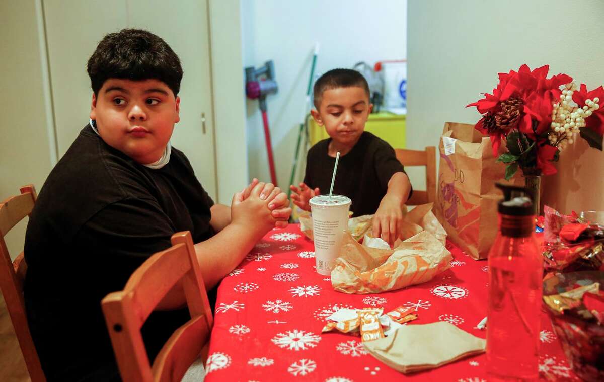 Victor Niu, 10, eats dinner with his 6-year-old brother, Angelo, in their San Francisco apartment.