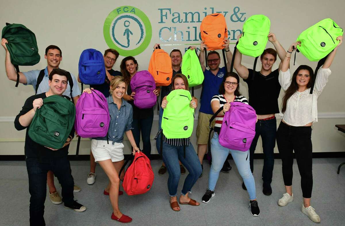 Volunteers from Albourne America, a local alternative investment firm, fill 80 backpacks with school supplies for children in Family & Children’s Agency programs Thursday, August 22, 2019, at the FCA facility at Ben Franklin School in Norwalk, Conn.
