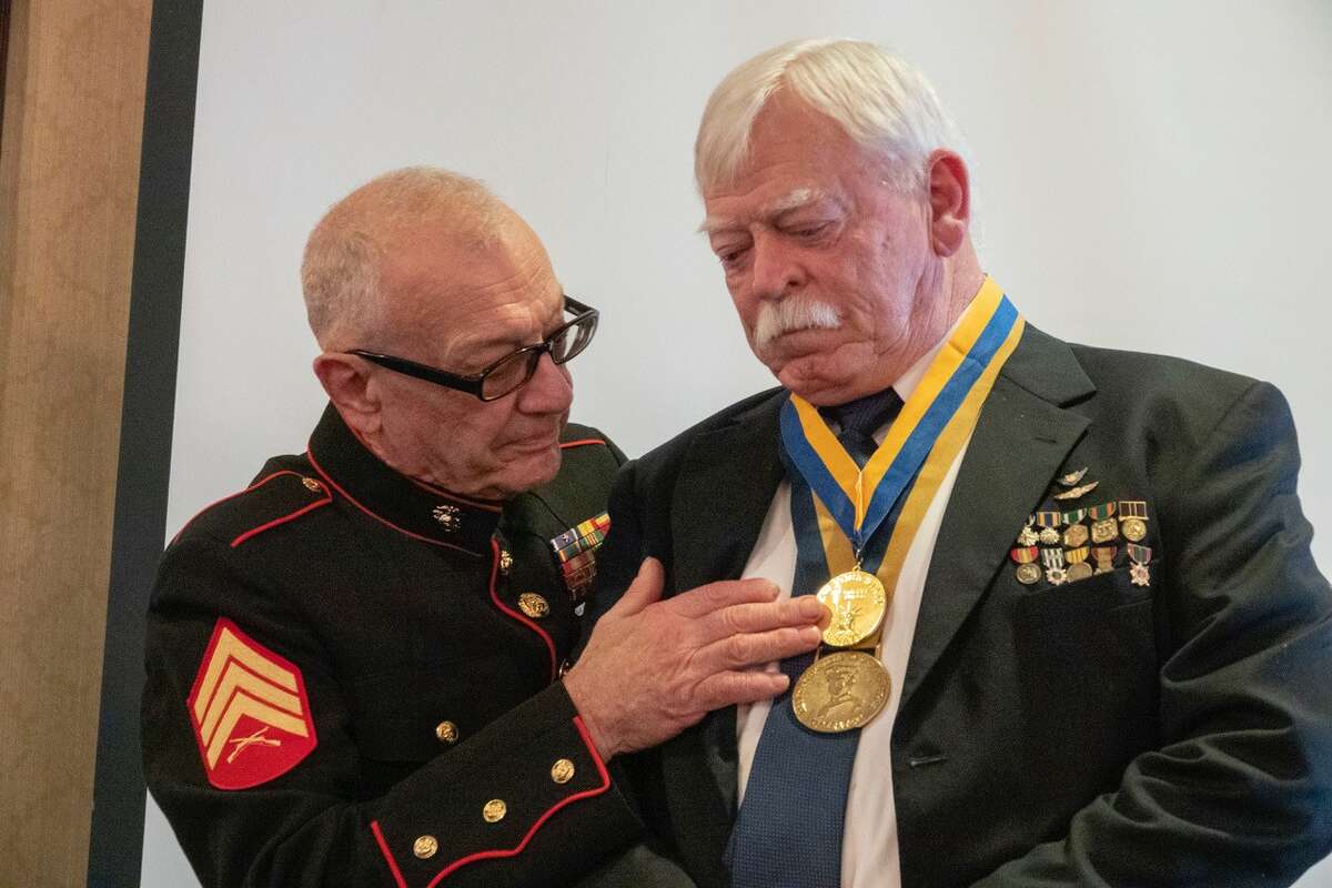(Ray Paulsen photo) Former Marine Sgt. Kenneth Wells presents a New York State Senate Liberty  Medal to David Terry Fox of Voorheesville during a ceremony in Latham.