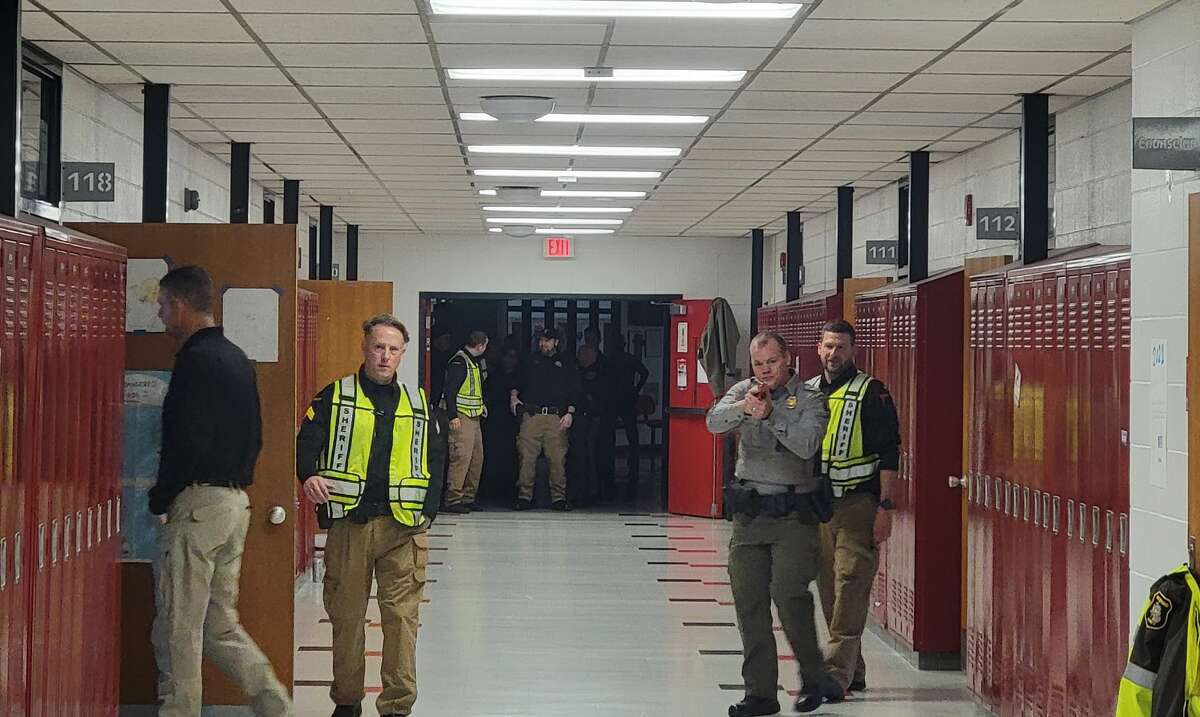 Law enforcement officers practice how to search for an active shooter when entering a school alone. 