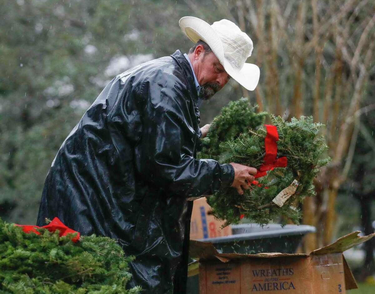 Jim Montgomery helps unload Christmas wreaths as volunteers laid 240 wreaths on veterans’ graves as part of Wreaths Across America at Oakwood Cemetery, Dec. 18, 2021, in Conroe.