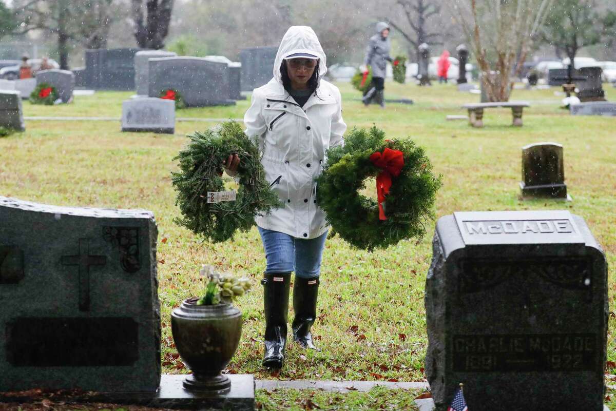 Veronica Westbrook carries Christmas wreaths as volunteers laid 240 wreaths on veterans’ graves as part of Wreaths Across America at Oakwood Cemetery, Dec. 18, 2021, in Conroe. This year's Wreaths Across America ceremony is set for 11 a.m. Saturday at Oakwood Cemetery in Conroe. 