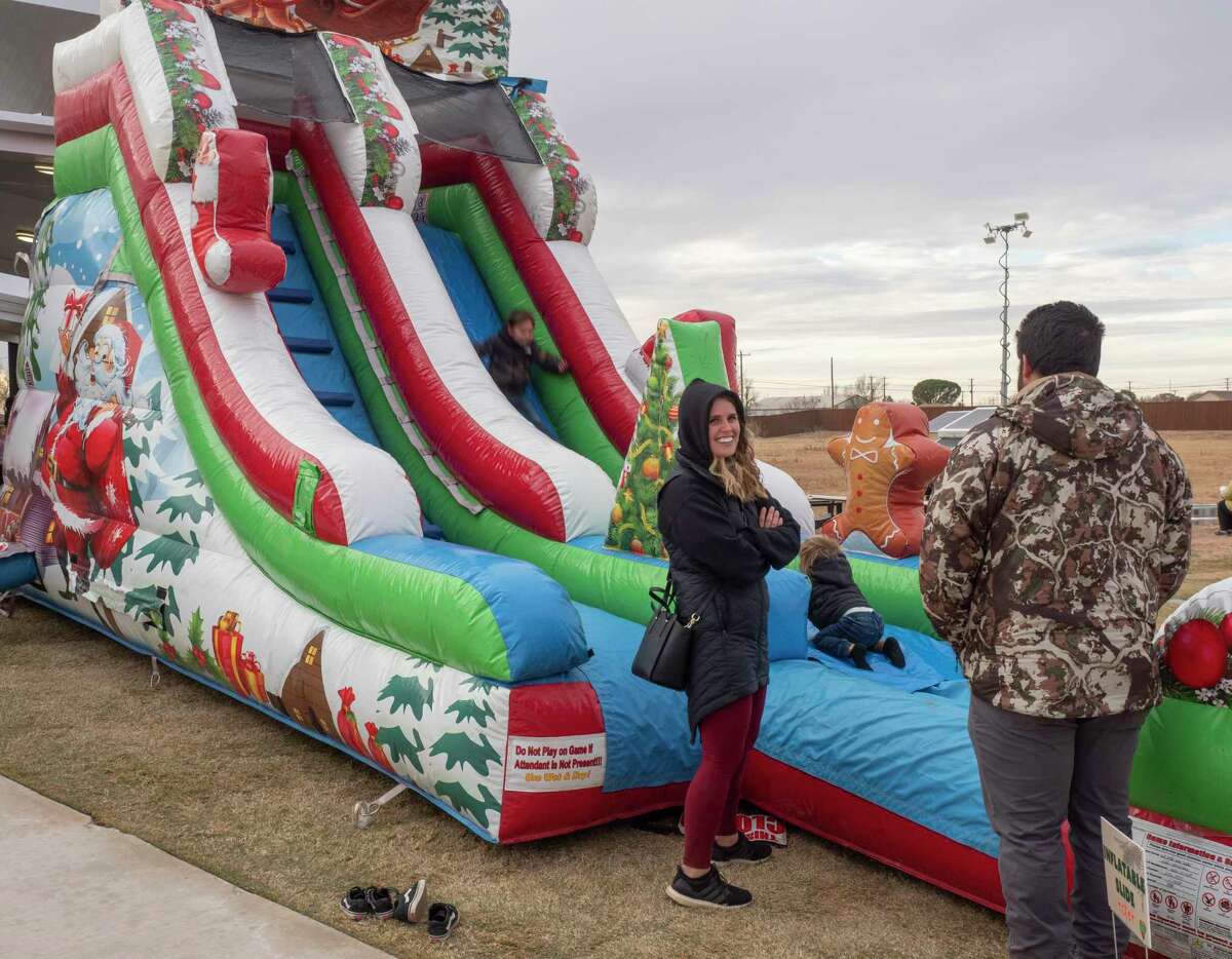 Children have fun on bouncy slides and jumpers as Midlanders enjoy a brisk game of miniature golf 12/18/2021 during the Christmas on the Green at Green Acres Miniature Golf. Tim Fischer/Reporter-Telegram