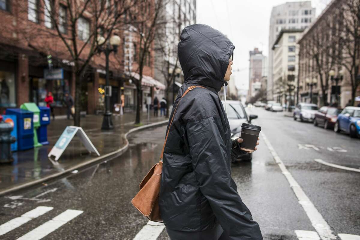 A woman crosses the road in rainy Seattle, Washington.