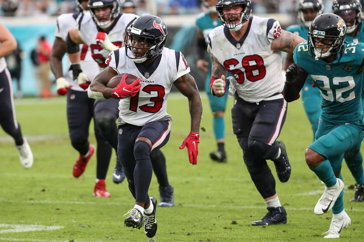 Houston Texans wide receiver Brandin Cooks (13) gets in the open field past Jacksonville Jaguars cornerback Tyson Campbell (32) on his way to a 43-yard touchdown catch and run during the fourth quarter of an NFL football game Sunday, Dec. 19, 2021, in Jacksonville.