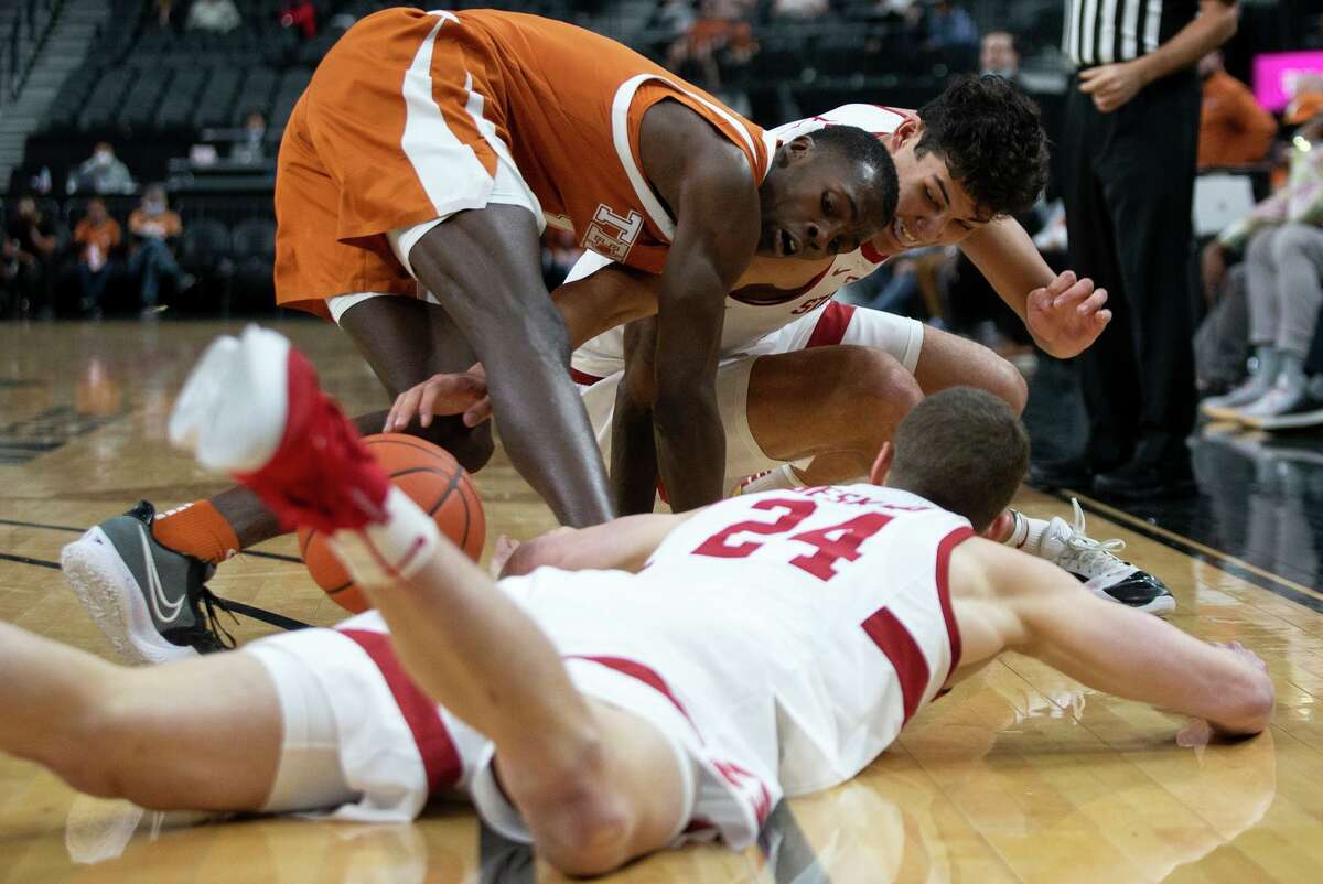 Texas guard Andrew Jones fights for a loose ball with guard Sam Beskind (24) and forward Brandon Angel of Stanford.
