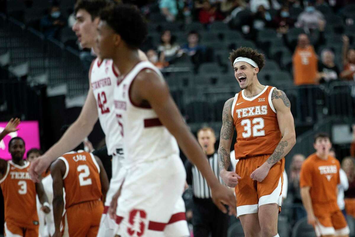 Texas forward Christian Bishop (32) celebrates after dunking while Stanford players walk toward the bench during the second half of a Pac-12 Coast-to-Coast Challenge NCAA college basketball game Sunday, Dec. 19, 2021, in Las Vegas. (AP Photo/Ellen Schmidt)