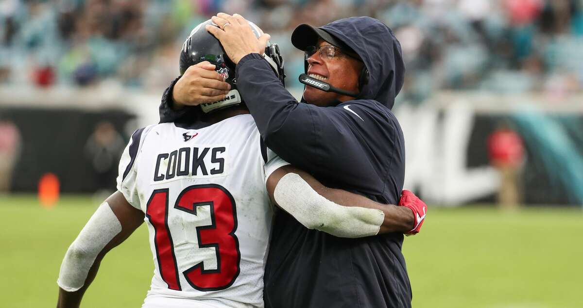 Houston Texans wide receiver Brandin Cooks (13) embraces head coach David Culley as they celebrate his 43-yard touchdown reception against the Jacksonville Jaguars during the fourth quarter of an NFL football game Sunday, Dec. 19, 2021, in Jacksonville.