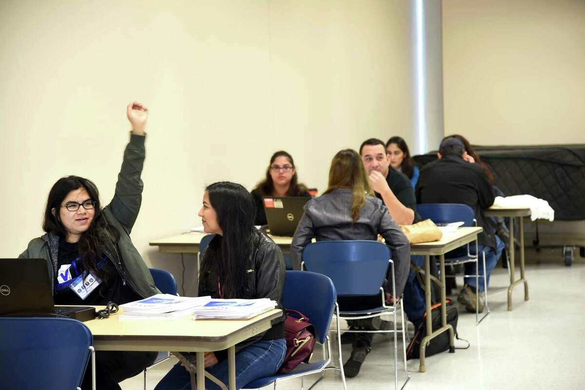 ARCHIVO - Voluntarios de VITA asisten a un evento de preparación de impuestos en la Biblioteca Pública de Laredo, el sábado 20 de enero de 2018.