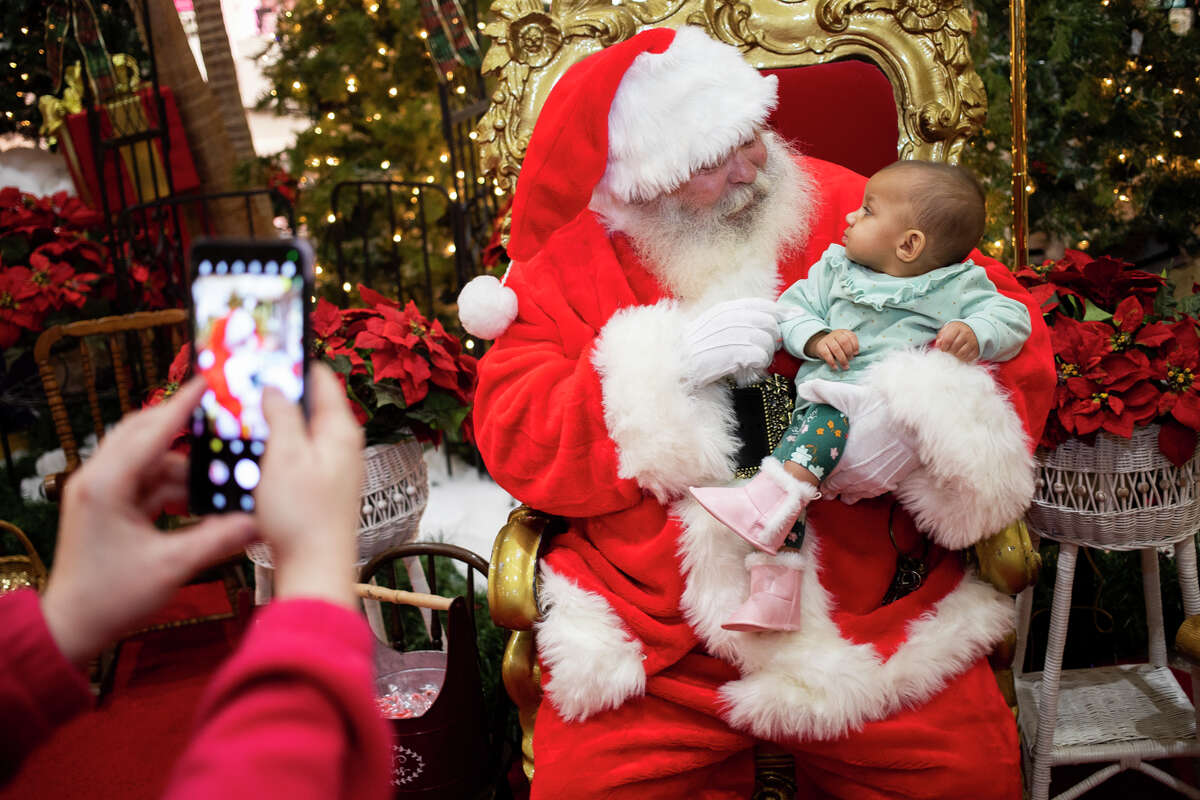 Mya Connyer, 7 months, looks up at Santa Claus as he asks her what she wants for Christmas Friday, Dec. 17, 2021 at the Midland Mall.