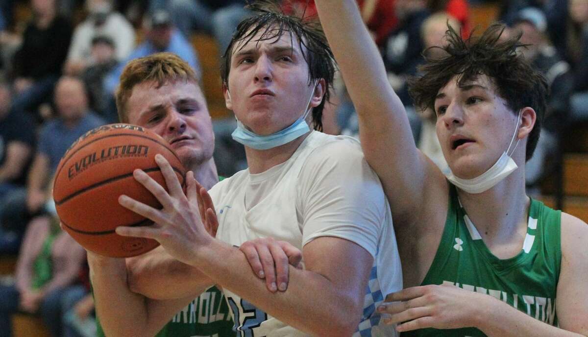 Triopia's Ryan Snow is fouled as he maneuvers in the lane during a boys' basketball game against Carrollton at Triopia Friday night.