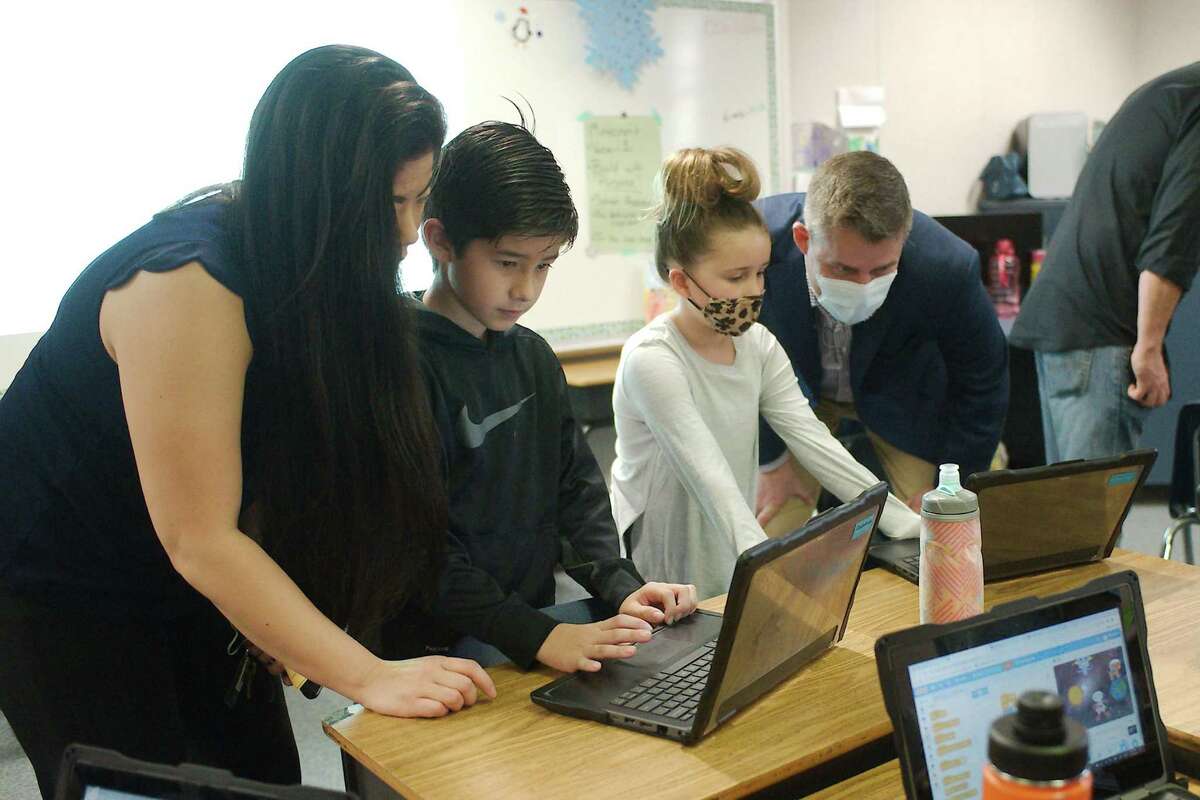 Lucas Yost presents his coding project to his mother, Allison, while Eva Daly presents her work to her father, Brendan, during a preview of the Robotics, Coding and Computational Thinking Program at Bauerschlag Elementary School.