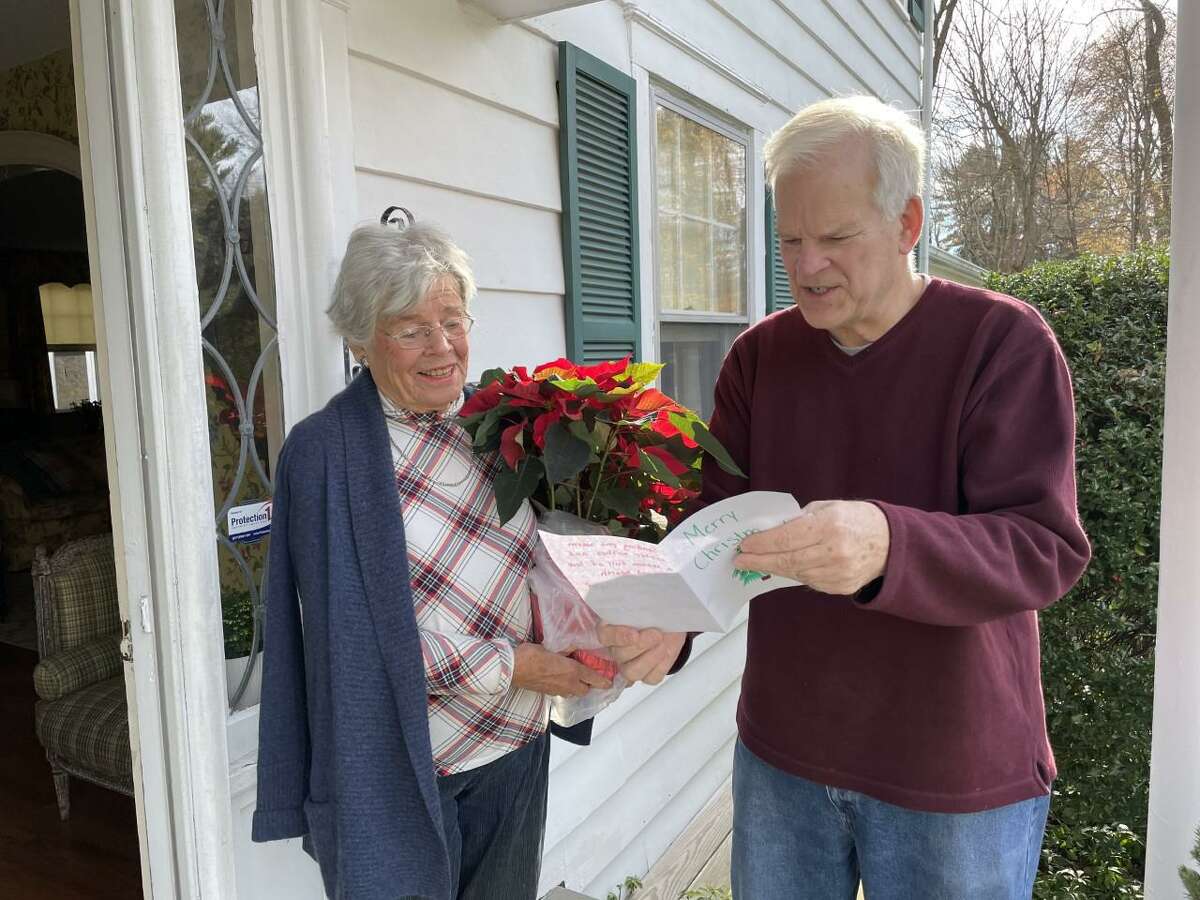 On Friday, Dec. 3, 26 volunteers made a surprise holiday delivery of poinsettia plants to the homes of 240 Staying Put in New Canaan members. Volunteer Tom Stadler delivers a surprise poinsettia plant to Staying Put member Tanis Erdmann.