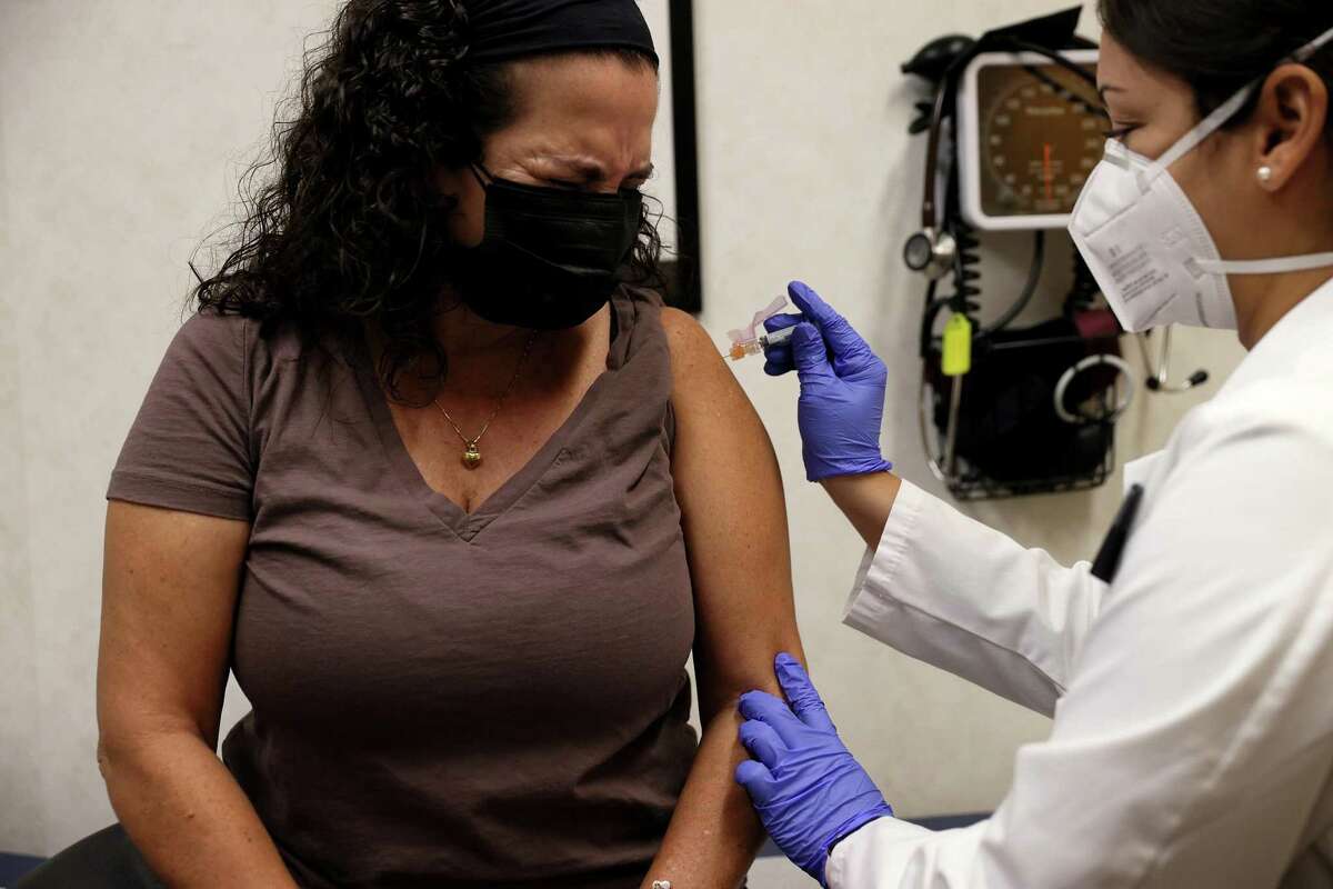 Susana Sanchez, a Nurse Practitioner, administers a flu vaccination to Ana Maria Flores at a CVS pharmacy and MinuteClinic on September 10, 2021 in Miami, Florida. CVS Health is offering the flu shots by appointment or walking in as health experts encourage people to get their flu shots in hopes of preventing a bad flu season.