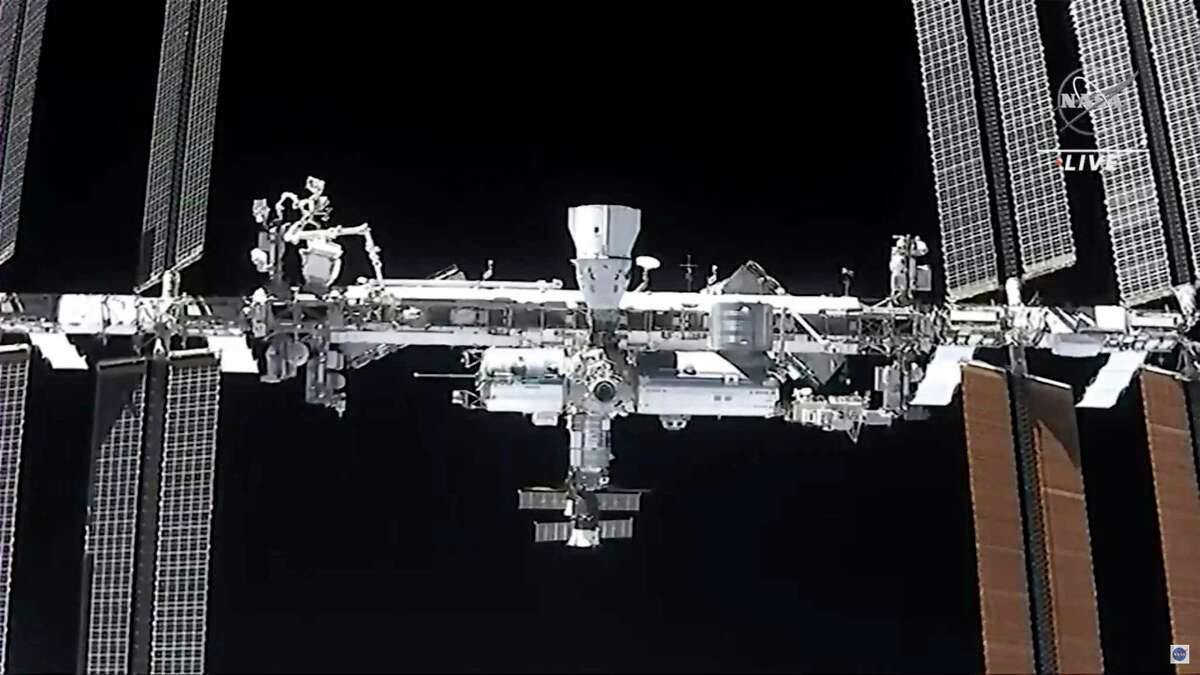 This image made from NASA TV shows the international space station, seen from the SpaceX Crew Dragon spacecraft.